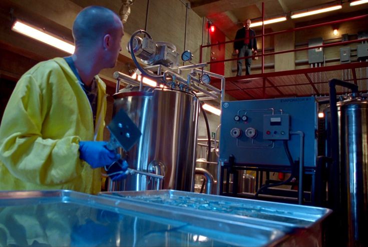 Jesse Pinkman in yellow hazmat suit cooking blue crystals in the superlab